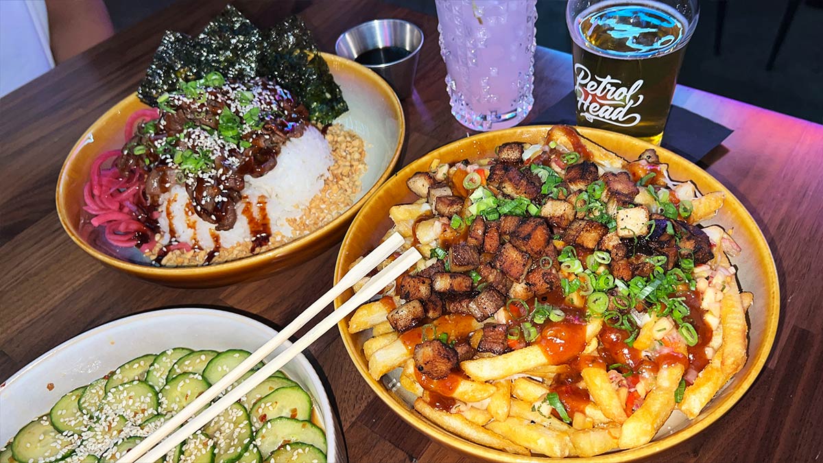 Bulgogi rice bowl, Kalua pork loaded fries, Japanese cucumber salad, cocktail, and beer at Petrol Head.