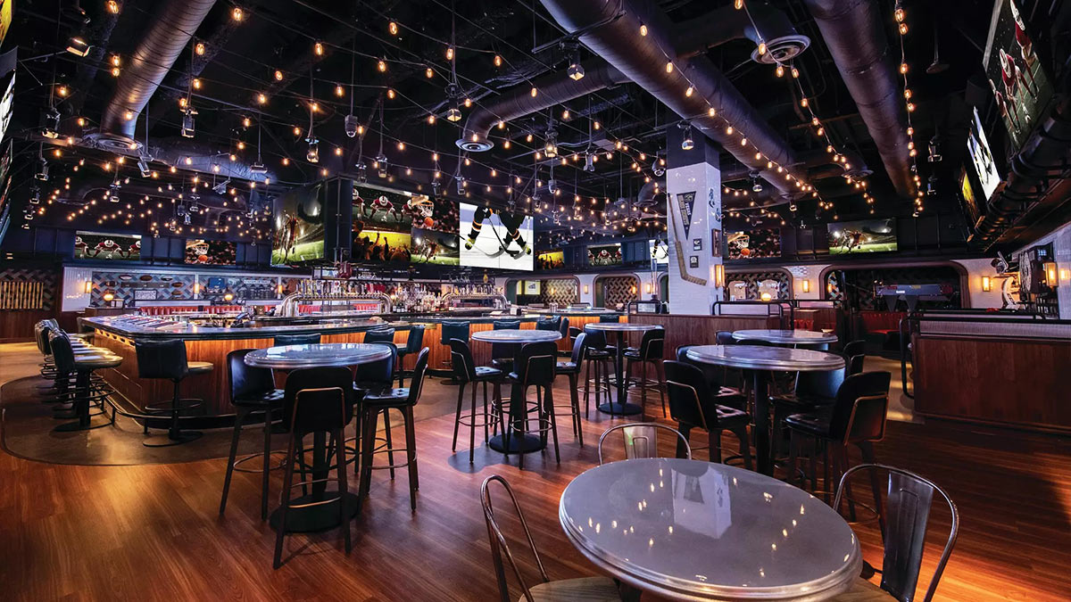 Sports bar interior at Park MGM with televisions, bar seating and tables