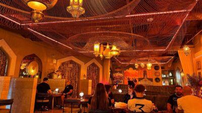 Main dining room inside Marrakech Mediterranean Restaurant with colorful Moroccan décor and low seating.