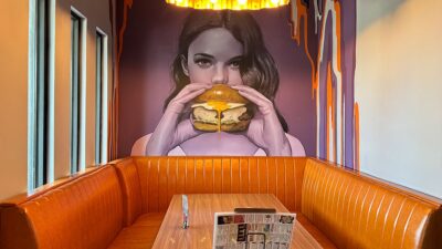 colorful wall art of a woman holding a burger inside Slater’s 50/50 on Lake Mead