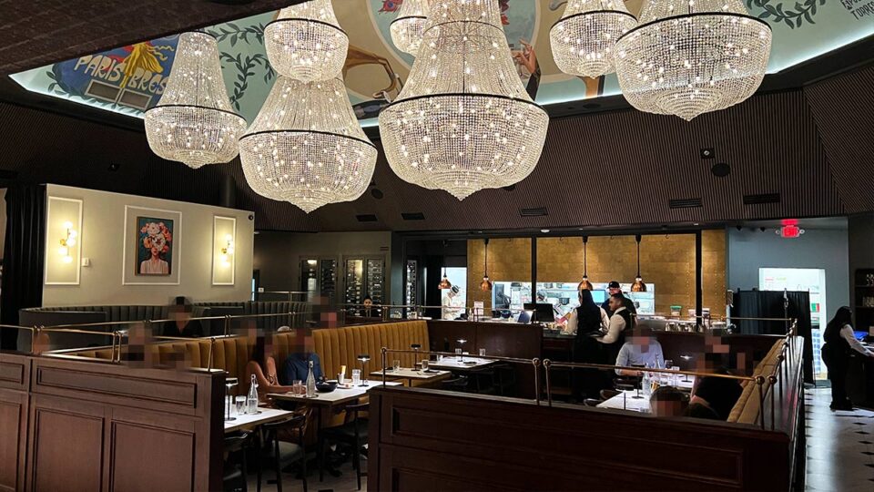 Dining room at Braseria by EDO with large crystal chandeliers and booth seating