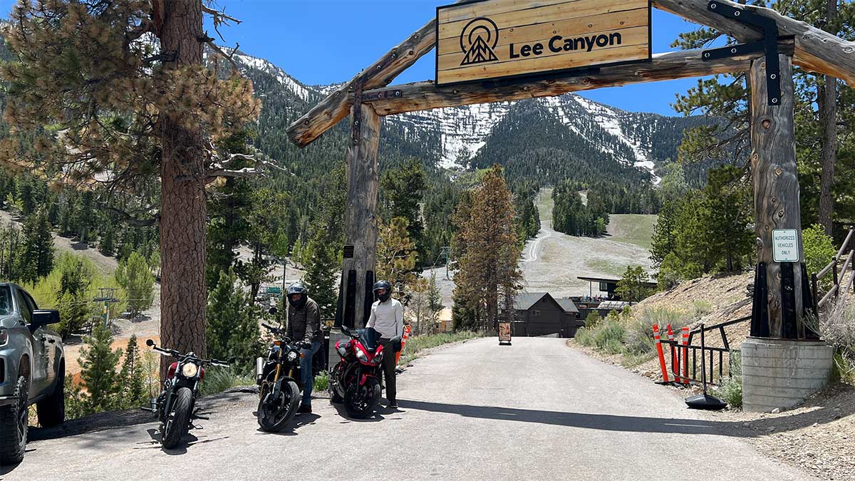 Lee Canyon entrance with motorcycles and snow-covered Spring Mountains in the background