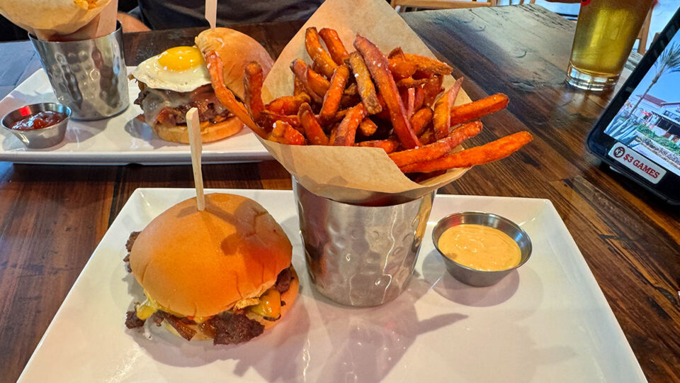Smashburger with grilled onions and sweet potato fries at Finney's Crafthouse