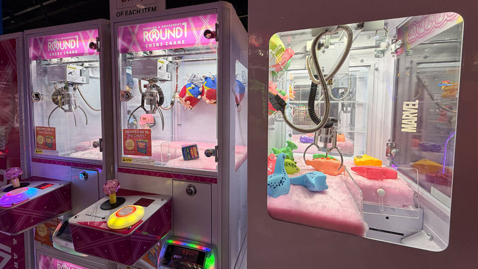 Two Round1 Chibi Crane arcade machines with pink interiors, claw mechanisms, and small colorful prizes.