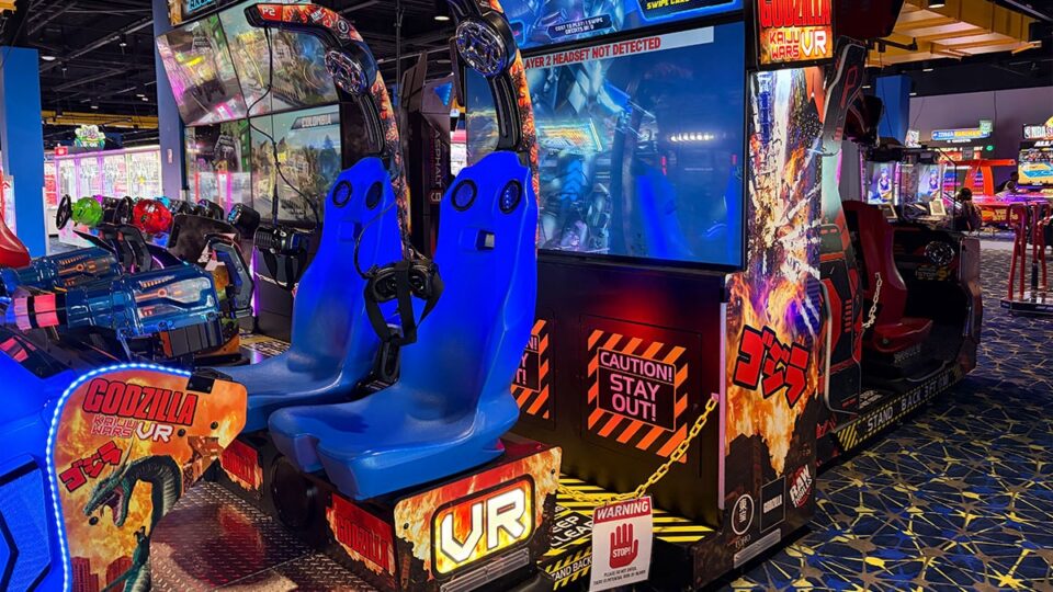 Godzilla Kaiju Wars VR arcade attraction with two blue motion-style seats, headsets, and a large game screen at Round1.